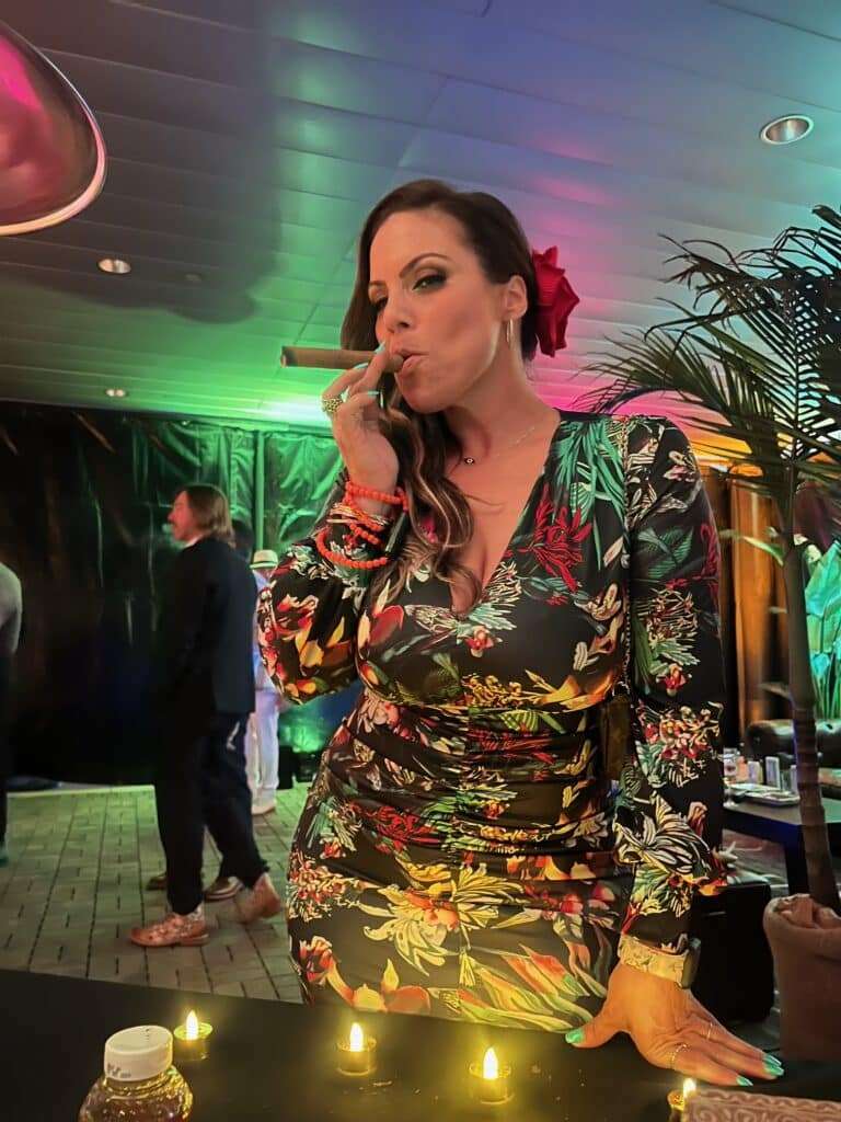 Woman enjoying hand rolled cigar from Cigar Bella, the cigar rollers Miami event attendees love.