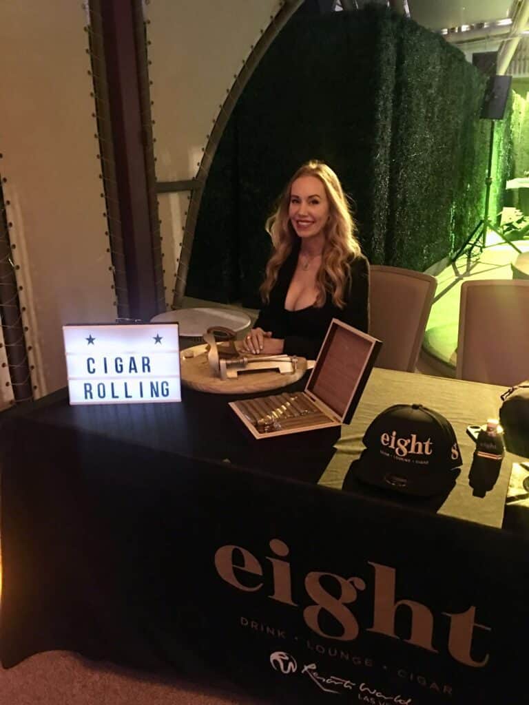 Cigar Bella, master cigar roller in Austin seated at cigar rolling station during corporate event.